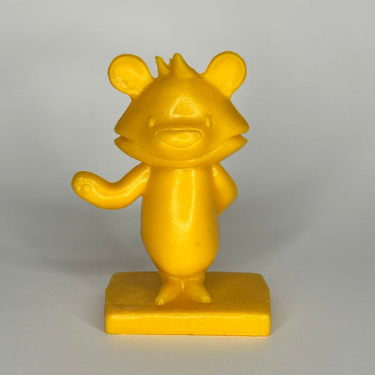 Yellow bear-like figurine on a gray background
